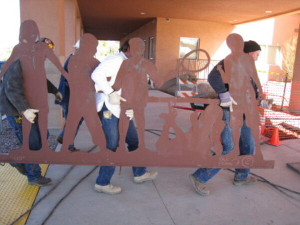 Volunteers carrying metal cutouts at the McDonald's RMHC facility during the 2008 Arizona Builders Alliance Volunteer Day.