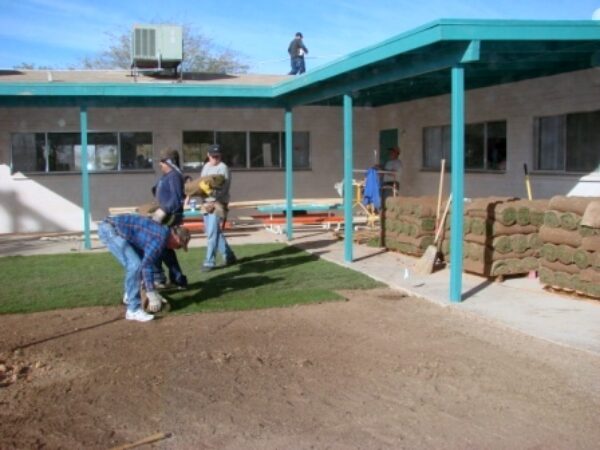 Volunteers rolling sod on a lawn during the 2010 Arizona Builders Alliance Volunteer Day landscaping project.